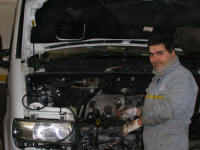 Mechanic working on the van. Note the gloves for cleanliness and scarf for warmth