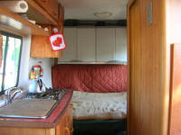 inside, kitchen on left, tiolet on right, bed at back