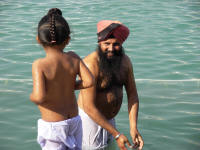 A Sikh man and his son immersing themselves