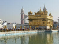 Causeway to the Golden Temple lined with people waiting to go inside.