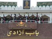 Pakistani soldiers preparing to march down in formation. Standing under a picture of Jinnah